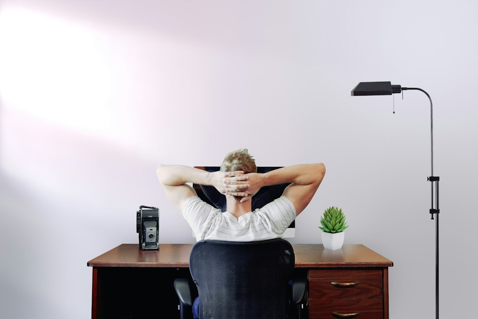 Bureau ergonomique, salarié ajustant sa posture et son écran pour limiter une douleur nerveuse.